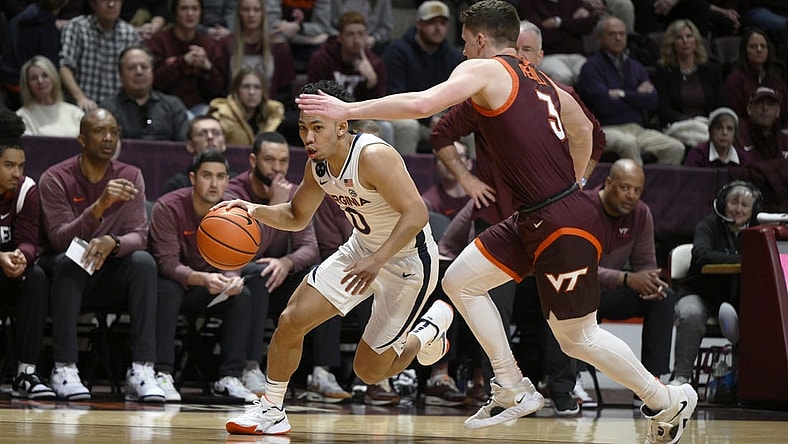 Feb 4, 2023; Blacksburg, Virginia, USA; Virginia Cavaliers guard Kihei Clark (0) dribbles around Virginia Tech Hokies guard Sean Pedulla (3) in the first half at Cassell Coliseum. Mandatory Credit: Lee Luther Jr.-USA TODAY Sports