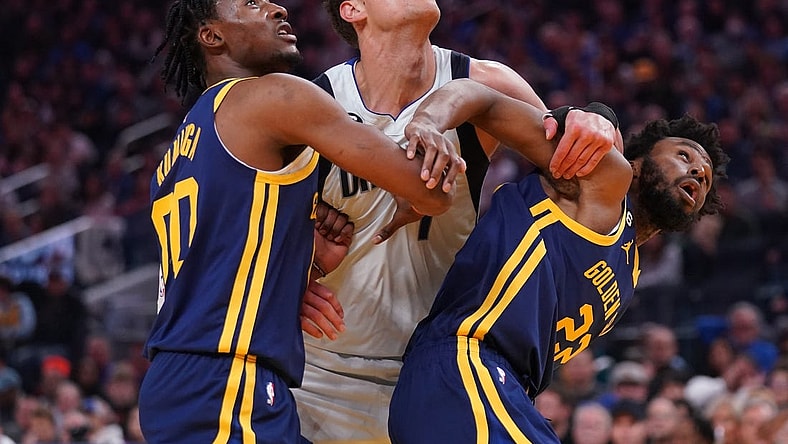 Feb 4, 2023; San Francisco, California, USA; Dallas Mavericks center Dwight Powell (7) battles for position against Golden State Warriors forward Jonathan Kuminga (00) and forward Andrew Wiggins (22) in the second quarter at the Chase Center. Mandatory Credit: Cary Edmondson-USA TODAY Sports