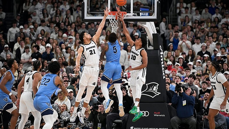 Feb 18, 2023; Providence, Rhode Island, USA;  Providence Friars forward Clifton Moore (21) and Providence Friars guard Noah Locke (10) defend the basket from Villanova Wildcats guard Justin Moore (5) during the first half at Amica Mutual Pavilion. Mandatory Credit: Eric Canha-USA TODAY Sports