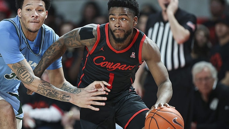 Feb 22, 2023; Houston, Texas, USA; Houston Cougars guard Jamal Shead (1) controls the ball as Tulane Green Wave forward Tylan Pope (33) defends during the second half at Fertitta Center. Mandatory Credit: Troy Taormina-USA TODAY Sports