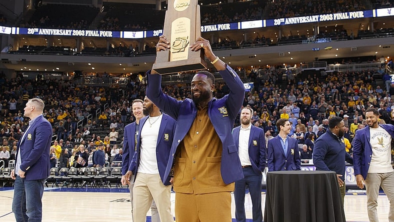 Jan 18, 2023; Milwaukee, Wisconsin, USA; Former Marquette Golden Eagles player Dwayne Wade holds up the 2003 Division One Semifinalist trophy during a ceremony honoring the 20th anniversary of reaching the Final Four during halftime of the game between the Providence Friars and Marquette Golden Eagles at Fiserv Forum. Mandatory Credit: Jeff Hanisch-USA TODAY Sports