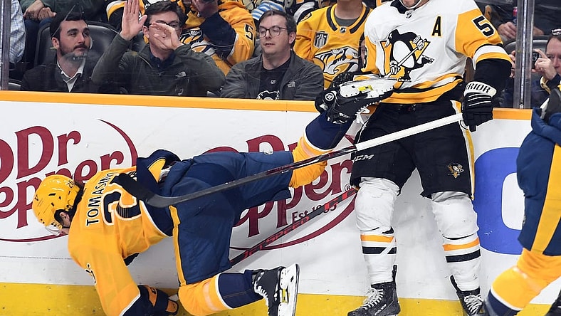 Feb 28, 2023; Nashville, Tennessee, USA; Nashville Predators center Philip Tomasino (26) is hit by Pittsburgh Penguins defenseman Kris Letang (58) during the third period at Bridgestone Arena. Mandatory Credit: Christopher Hanewinckel-USA TODAY Sports