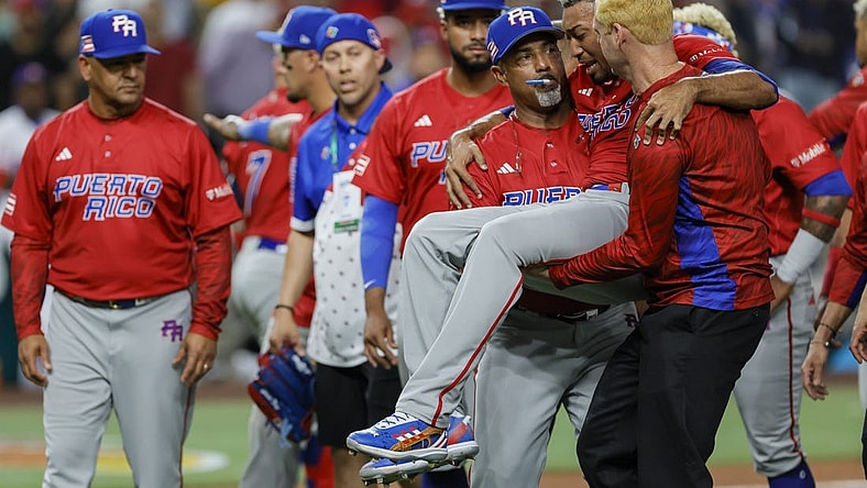 Mar 15, 2023; Miami, Florida, USA; Puerto Rico pitcher Edwin Diaz (39) gets taken off the field by pitching coach Ricky Bones (27) after an apparent leg injury during the team celebration against Dominican Republic at LoanDepot Park. Mandatory Credit: Sam Navarro-USA TODAY Sports