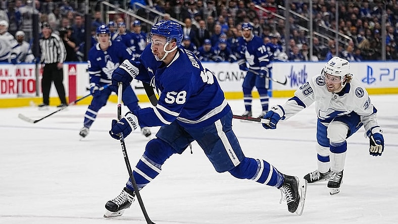 Apr 18, 2023; Toronto, Ontario, CAN; Toronto Maple Leafs forward Michael Bunting (58) shoots the puck as Tampa Bay Lightning forward Brandon Hagel (38) closes in during the first period of game one of the first round of the 2023 Stanley Cup Playoffs at Scotiabank Arena. Mandatory Credit: John E. Sokolowski-USA TODAY Sports