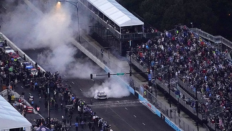 Jul 2, 2023; Chicago, Illinois, USA; NASCAR Cup Series driver Shane Van Gisbergen (91) does a burn out after winning the Grant Park 220 of the Chicago Street Race viewed from the NEMA Chicago buliding. Mandatory Credit: Jon Durr-USA TODAY Sports