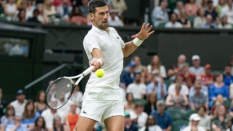 Jul 7, 2023; London, United Kingdom; Novak Djokovic (SRB) returns a shot during his match against Stanislas Wawrinka (SUI) on day five of Wimbledon at the All England Lawn Tennis and Croquet Club.  Mandatory Credit: Susan Mullane-USA TODAY Sports
