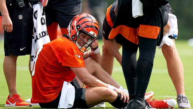 Cincinnati Bengals quarterback Joe Burrow (9) grabs his calf after an injury on a scramble play during NFL football training camp, Thursday, July 27, 2023, in Cincinnati. (Kareem Elgazzar/The Cincinnati Enquirer via AP)