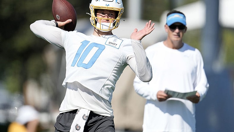Jul 26, 2023; Costa Mesa, CA, USA; Los Angeles Chargers quarterback Justin Herbert (10) throws the ball as quarterbacks coach Doug Nussmeier watches during training camp at Jack Hammett Sports Complex. Mandatory Credit: Kirby Lee-USA TODAY Sports