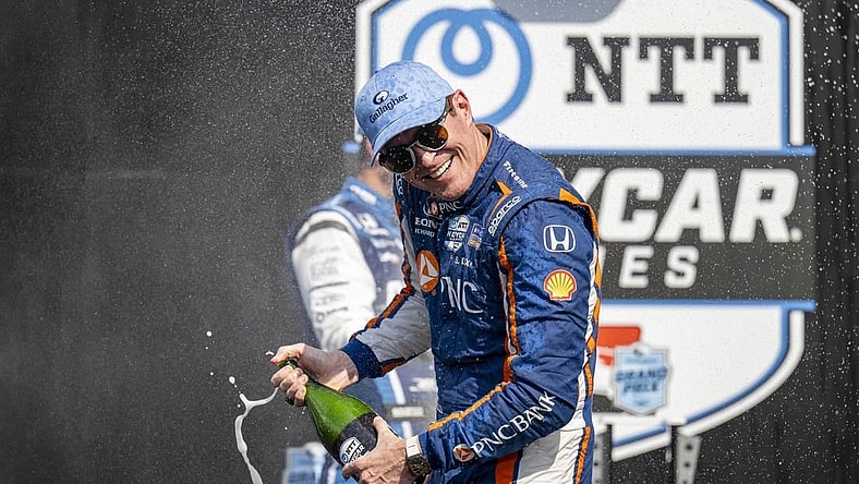 Aug 12, 2023; Speedway, Indiana, USA; Chip Ganassi Racing driver Scott Dixon (9) turns away from Rahal Letterman Lanigan Racing driver Graham Rahal (15) during the champagne fight on the podium after the Gallagher Grand Prix at the Indianapolis Motor Speedway Road Course. Mandatory Credit: Marc Lebryk-USA TODAY Sports