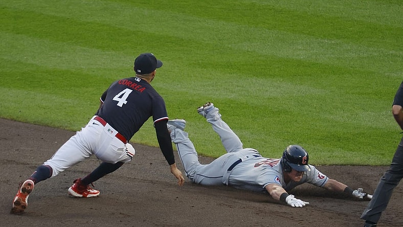 Aug 29, 2023; Minneapolis, Minnesota, USA; Cleveland Guardians first baseman Kole Calhoun (26) slides into second base for a double before Minnesota Twins shortstop Carlos Correa (4) can tag him in the third inning at Target Field. Mandatory Credit: Bruce Kluckhohn-USA TODAY Sports