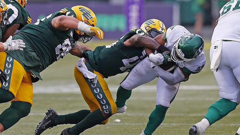 Jun 11, 2023; Edmonton, Alberta, CAN; Saskatchewan Roughriders running back Frankie Hickson (20) is tackled by Edmonton Elks linebacker Myles Morgan (45) during the second half at Commonwealth Stadium. Mandatory Credit: Perry Nelson-USA TODAY Sports