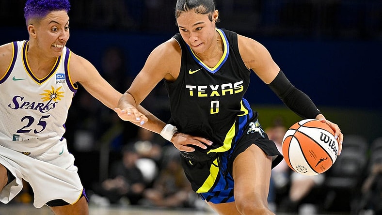 Jul 22, 2023; Arlington, Texas, USA; Dallas Wings forward Satou Sabally (0) drives to the basket past Los Angeles Sparks guard Layshia Clarendon (25) during the second quarter at College Park Center. Mandatory Credit: Jerome Miron-USA TODAY Sports