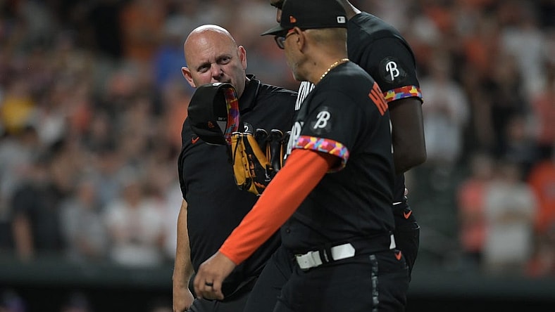 Aug 25, 2023; Baltimore, Maryland, USA; Baltimore Orioles relief pitcher Felix Bautista (74) walks off the field with major league coach Jos  Hern ndez (59) and team trainer during the ninth inning against the Colorado Rockies  at Oriole Park at Camden Yards. Mandatory Credit: Tommy Gilligan-USA TODAY Sports