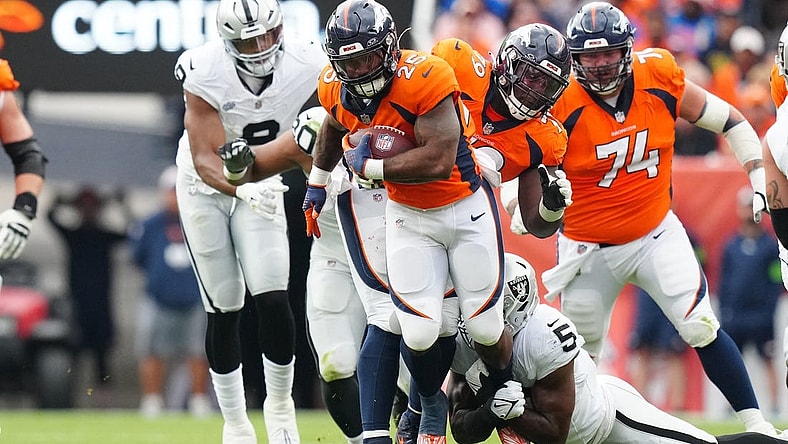 Sep 10, 2023; Denver, Colorado, USA; Las Vegas Raiders linebacker Divine Deablo (5) tackles Denver Broncos running back Samaje Perine (25) in the second quarter at Empower Field at Mile High. Mandatory Credit: Ron Chenoy-USA TODAY Sports