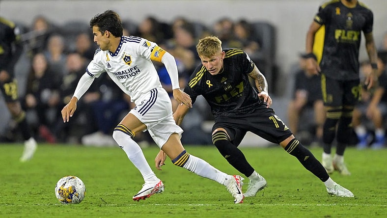 Sep 16, 2023; Los Angeles, California, USA; Los Angeles Galaxy midfielder Riqui Puig (6) keeps the ball from Los Angeles FC midfielder Mateusz Bogusz (19) in the second half at BMO Stadium. Mandatory Credit: Jayne Kamin-Oncea-USA TODAY Sports