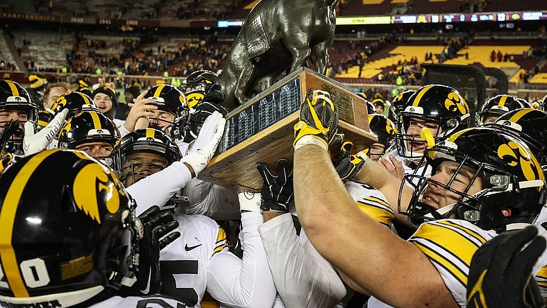 Nov 19, 2022; Minneapolis, Minnesota, USA; Iowa Hawkeyes players celebrate with the Floyd of Rosedale after defeating the Minnesota Golden Gophers at Huntington Bank Stadium. Mandatory Credit: Matt Krohn-USA TODAY Sports