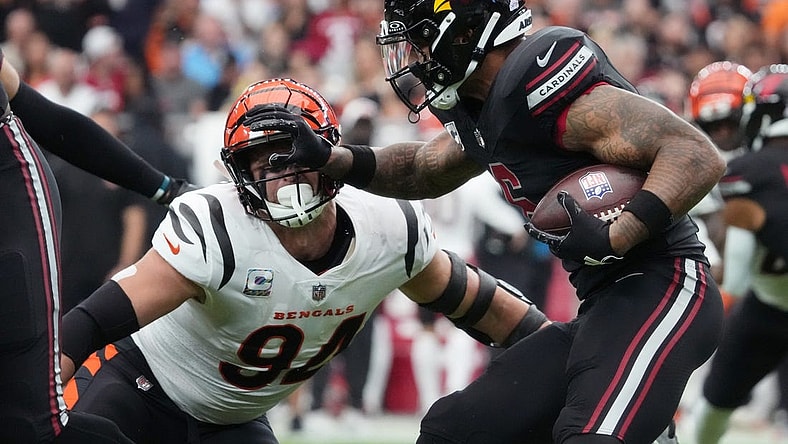 Oct 8, 2023; Glendale, Arizona, United States; Arizona Cardinals running back James Conner (6) stiff arms Cincinnati Bengals defensive end Sam Hubbard (94) at State Farm Stadium. Mandatory Credit: Joe Rondone-USA TODAY Sports
