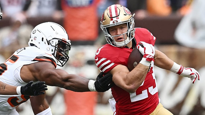 Oct 15, 2023; Cleveland, Ohio, USA; San Francisco 49ers running back Christian McCaffrey (23) runs from Cleveland Browns defensive end Myles Garrett (95) during the first half at Cleveland Browns Stadium. Mandatory Credit: Ken Blaze-USA TODAY Sports