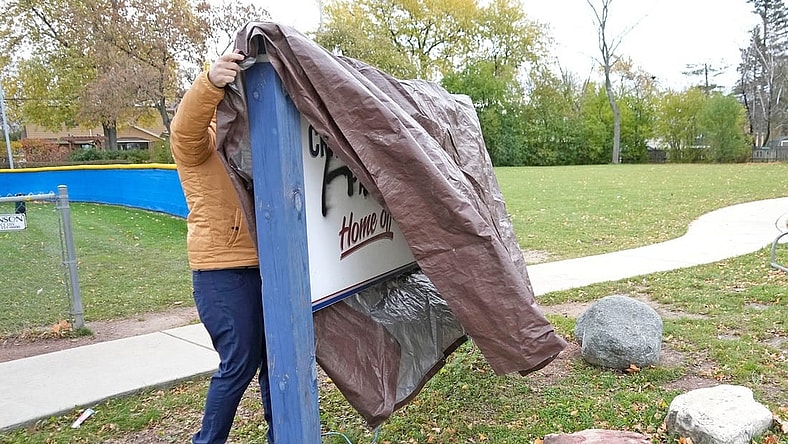 A man who wished to remain unidentified covers up a sign outside Craig Counsell Park on North Lydell Avenue that was vandalized in the last day with spray paint in Whitefish Bay on Tuesday, Nov. 7, 2023. Counsell signed a record-breaking contract to manage the Chicago Cubs.