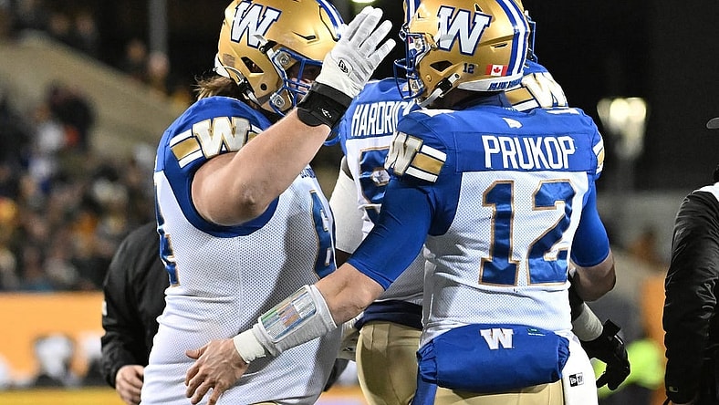 Nov 19, 2023; Hamilton, Ontario, CAN; Winnipeg Blue Bombers quarterback Dakota Prukop (12) celebrates with offensive lineman Liam Dobson (64) after scoring a touchdown against the Montreal Alouettes in the first half at Tim Hortons Field. Mandatory Credit: Dan Hamilton-USA TODAY Sports