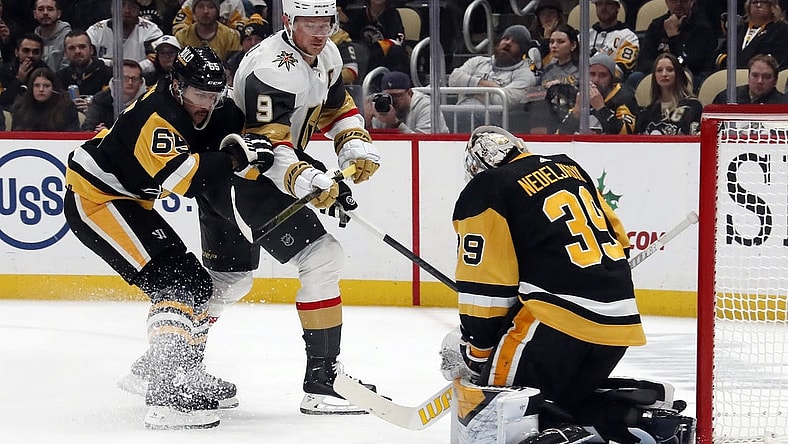 Nov 19, 2023; Pittsburgh, Pennsylvania, USA; Pittsburgh Penguins goaltender Alex Nedeljkovic (39) makes a save against Vegas Golden Knights center Jack Eichel (9) as Pens defenseman Erik Karlsson (65) defends during the second period at PPG Paints Arena. Pittsburgh won 3-0. Mandatory Credit: Charles LeClaire-USA TODAY Sports