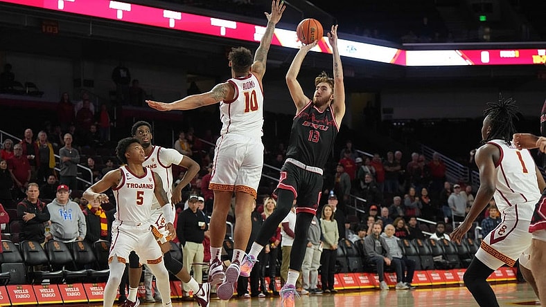 Nov 29, 2023; Los Angeles, California, USA; Eastern Washington Eagles guard Jake Kyman (13) shoots the ball against Southern California Trojans forward DJ Rodman (10)  in the first half at Galen Center. Mandatory Credit: Kirby Lee-USA TODAY Sports