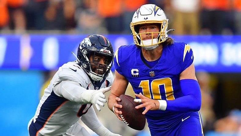 Dec 10, 2023; Inglewood, California, USA; Los Angeles Chargers quarterback Justin Herbert (10) moves out to pass against the defense of Denver Broncos linebacker Jonathon Cooper (0) during the first half at SoFi Stadium. Mandatory Credit: Gary A. Vasquez-USA TODAY Sports
