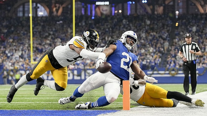 Dec 16, 2023; Indianapolis, Indiana, USA; Indianapolis Colts running back Zack Moss (21) slides into the end zone for a touchdown while being chased by Pittsburgh Steelers linebacker Elandon Roberts (50) and Pittsburgh Steelers linebacker Mykal Walker (38) during a game against the Pittsburgh Steelers at Lucas Oil Stadium. Mandatory Credit: Robert Scheer-USA TODAY Sports