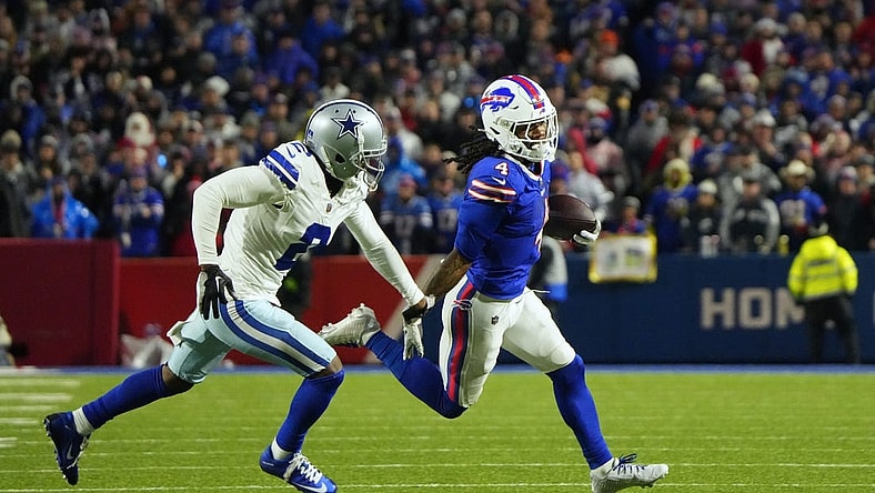 Dec 17, 2023; Orchard Park, New York, USA; Buffalo Bills running back James Cook (4) runs the ball pressured by Dallas Cowboys cornerback Jourdan Lewis (2) in the first half at Highmark Stadium. Mandatory Credit: Gregory Fisher-USA TODAY Sports