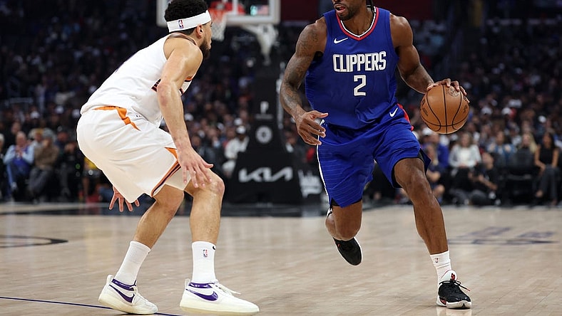 Jan 8, 2024; Los Angeles, California, USA; Los Angeles Clippers forward Kawhi Leonard (2) dribbles the ball against Phoenix Suns guard Devin Booker (1) during the first quarter at Crypto.com Arena. Mandatory Credit: Kiyoshi Mio-USA TODAY Sports