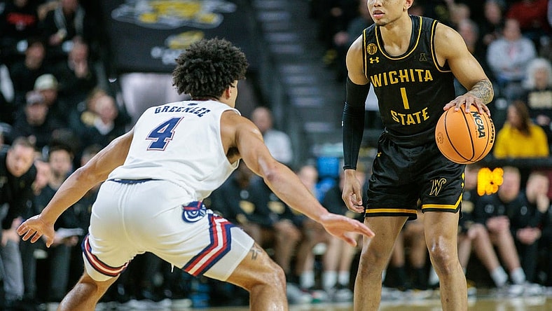 Feb 11, 2024; Wichita, Kansas, USA; Wichita State Shockers guard Xavier Bell (1) dribbles the ball against Florida Atlantic Owls guard Bryan Greenlee (4) during the first half at Charles Koch Arena. Mandatory Credit: William Purnell-USA TODAY Sports