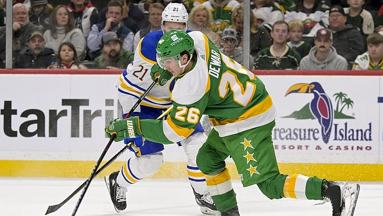 Feb 17, 2024; Saint Paul, Minnesota, USA;  Minnesota Wild forward Connor Dewar (26) clears the puck on a penalty kill against the Buffalo Sabres during the first period at Xcel Energy Center. Mandatory Credit: Nick Wosika-USA TODAY Sports