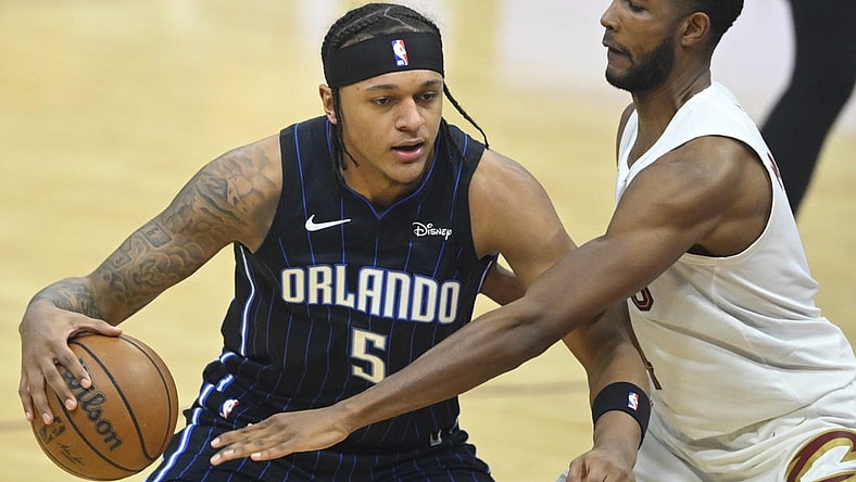 Feb 22, 2024; Cleveland, Ohio, USA; Orlando Magic forward Paolo Banchero (5) dribbles beside Cleveland Cavaliers forward Evan Mobley (4) in the first quarter at Rocket Mortgage FieldHouse. Mandatory Credit: David Richard-USA TODAY Sports