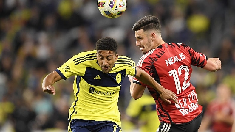 Feb 25, 2024; Nashville, Tennessee, USA; Nashville SC forward McKinze Gaines (17) goes up for a header against New York Red Bulls defender Dylan Nealis (12) at Geodis Park. Mandatory Credit: Steve Roberts-USA TODAY Sports