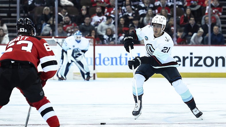 Feb 12, 2024; Newark, New Jersey, USA; Seattle Kraken center Alex Wennberg (21) skates with the puck against as New Jersey Devils left wing Jesper Bratt (63) defends during the first period at Prudential Center. Mandatory Credit: John Jones-USA TODAY Sports