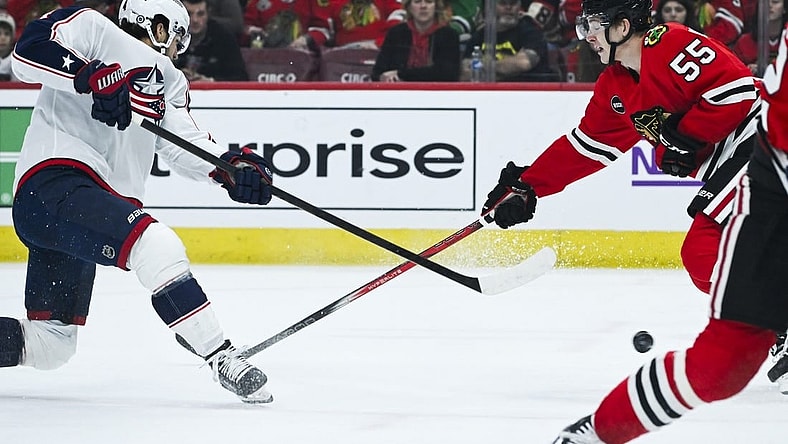 Mar 2, 2024; Chicago, Illinois, USA;  Columbus Blue Jackets center Cole Sillinger (4) shoots the puck against Chicago Blackhawks defenseman Kevin Korchinski (55) during the first period at the  United Center. Mandatory Credit: Matt Marton-USA TODAY Sports