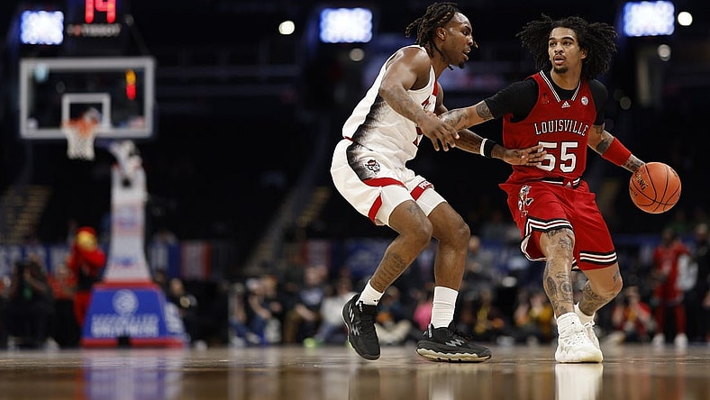 Mar 12, 2024; Washington, D.C., USA; Louisville Cardinals guard Skyy Clark (55) drives to the basket as North Carolina State Wolfpack guard Jayden Taylor (1) defends in the first half at Capital One Arena. Mandatory Credit: Geoff Burke-USA TODAY Sports