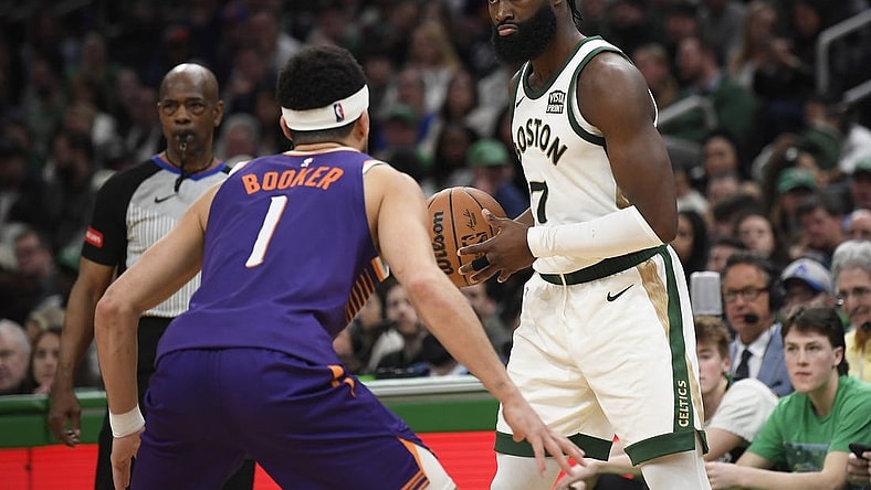 Mar 14, 2024; Boston, Massachusetts, USA;  Boston Celtics guard Jaylen Brown (7) controls the ball while Phoenix Suns guard Devin Booker (1) defends during the second half at TD Garden. Mandatory Credit: Bob DeChiara-USA TODAY Sports