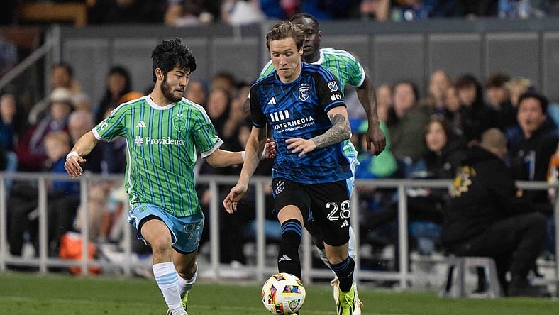 Mar 23, 2024; San Jose, California, USA; San Jose Earthquakes forward Benji Kikanovic (28) dribbles the ball while Seattle Sounders FC midfielder Dylan Teves (99) defends during the second half at PayPal Park. Mandatory Credit: Stan Szeto-USA TODAY Sports
