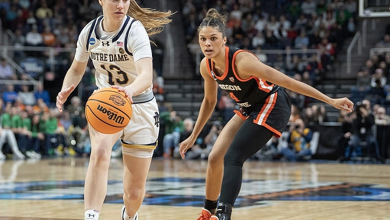 Mar 29, 2024; Albany, NY, USA; Notre Dame Fighting Irish guard Anna DeWolfe (13) dribbles the ball past Oregon State Beavers guard Donovyn Hunter (4) during the first half in the semifinals of the Albany Regional of the 2024 NCAA Tournament at the MVP Arena at MVP Arena. Mandatory Credit: Gregory Fisher-USA TODAY Sports