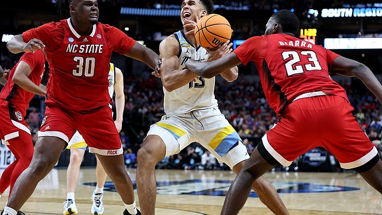 Mar 29, 2024; Dallas, TX, USA; North Carolina State Wolfpack forward Mohamed Diarra (23) knocks the ball away from Marquette Golden Eagles forward Oso Ighodaro (13) as North Carolina State Wolfpack forward DJ Burns Jr. (30) defends during the second half in the semifinals of the South Regional of the 2024 NCAA Tournament at American Airlines Center. Mandatory Credit: Tim Heitman-USA TODAY Sports