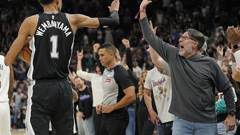 Mar 29, 2024; San Antonio, Texas, USA; San Antonio Spurs forward Victor Wembanyama (1) and a fan react after an overtime victory over the New York Knicks at Frost Bank Center. Mandatory Credit: Scott Wachter-USA TODAY Sports