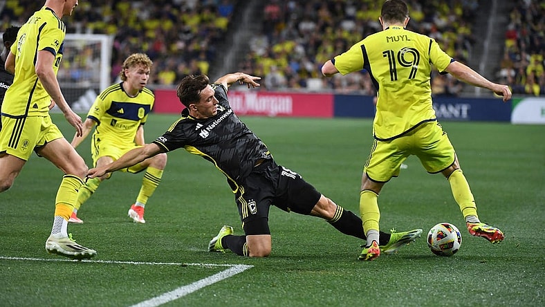 Mar 30, 2024; Nashville, Tennessee, USA; Columbus Crew defender Malte Amundsen (18) kick the ball away from Nashville SC midfielder Alex Muyl (19) in the second half at Geodis Park. Mandatory Credit: Christopher Hanewinckel-USA TODAY Sports