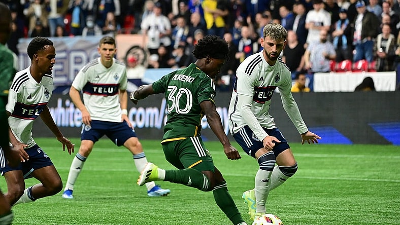 Mar 30, 2024; Vancouver, British Columbia, CAN; Portland Timbers forward Santiago Moreno (30) shoots as Vancouver Whitecaps FC defender Tristan Blackmon (6) defends during the first half at BC Place. Mandatory Credit: Simon Fearn-USA TODAY Sports