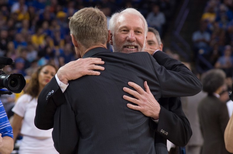 Caption: April 7, 2016; Oakland, CA, USA; San Antonio Spurs head coach Gregg Popovich hugs Golden State Warriors head coach Steve Kerr before the game at Oracle Arena. The Warriors defeated the Spurs 112-101. Mandatory Credit: Kyle Terada-USA TODAY Sports