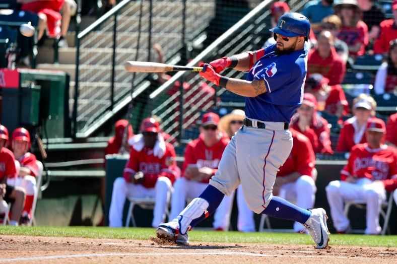 Caption: Mar 23, 2017; Surprise, AZ, USA; Texas Rangers second baseman Rougned Odor (12) runs to first with his bat as he flew out during the fourth inning against the Los Angeles Dodgers at Surprise Stadium. Mandatory Credit: Jake Roth-USA TODAY Sports