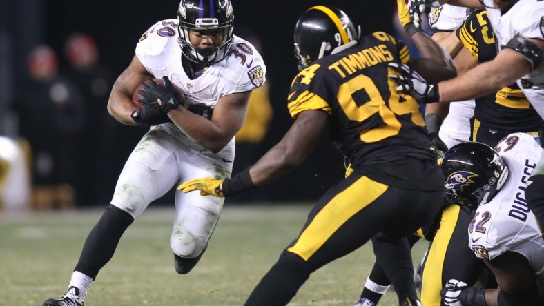 Dec 25, 2016; Pittsburgh, PA, USA; Baltimore Ravens running back Kenneth Dixon (30) rushes the ball against Pittsburgh Steelers inside linebacker Lawrence Timmons (94) during the fourth quarter at Heinz Field. The Steelers won 31-27. Mandatory Credit: Charles LeClaire-USA TODAY Sports