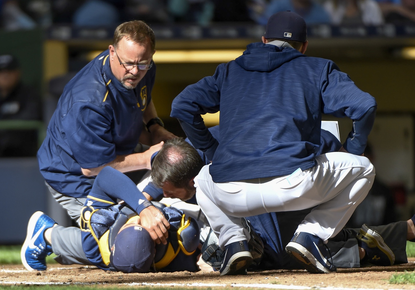 Apr 1, 2017; Milwaukee, WI, USA; Milwaukee Brewers catcher Jett Bandy (47) checks on Rene Garcia after Garcia was injured in the ninth inning during the game against the Chicago White Sox and had to be carted off the field at Miller Park. Mandatory Credit: Benny Sieu-USA TODAY Sports