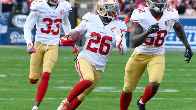 Dec 24, 2016; Los Angeles, CA, USA; San Francisco 49ers cornerback Tramaine Brock (center) runs upfield with a first quarter interception followed by cornerback Rashard Robinson (33) and outside linebacker Eli Harold (58) on a pass intended for Los Angeles Rams wide receiver Tavon Austin (not pictured) at Los Angeles Memorial Coliseum. Mandatory Credit: Robert Hanashiro-USA TODAY Sports