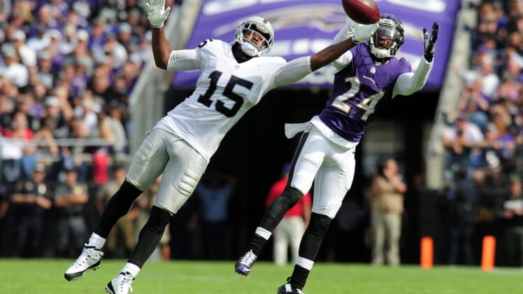 Michael Crabtree and Shareece Wright battle for a ball